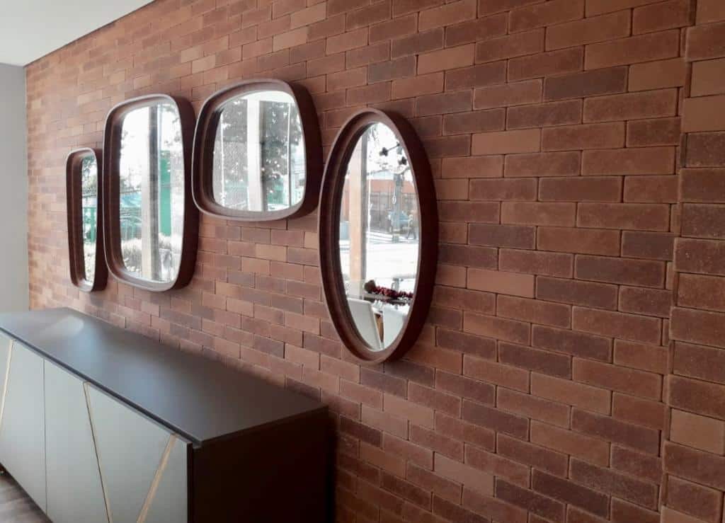 parede de tijolinhos brick Estoril decorada com aparador e espelhos